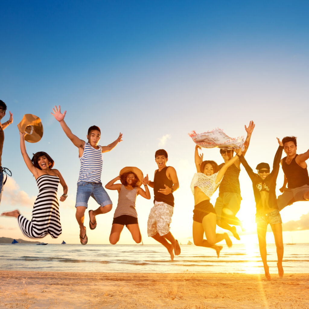group of friends jumping on beach