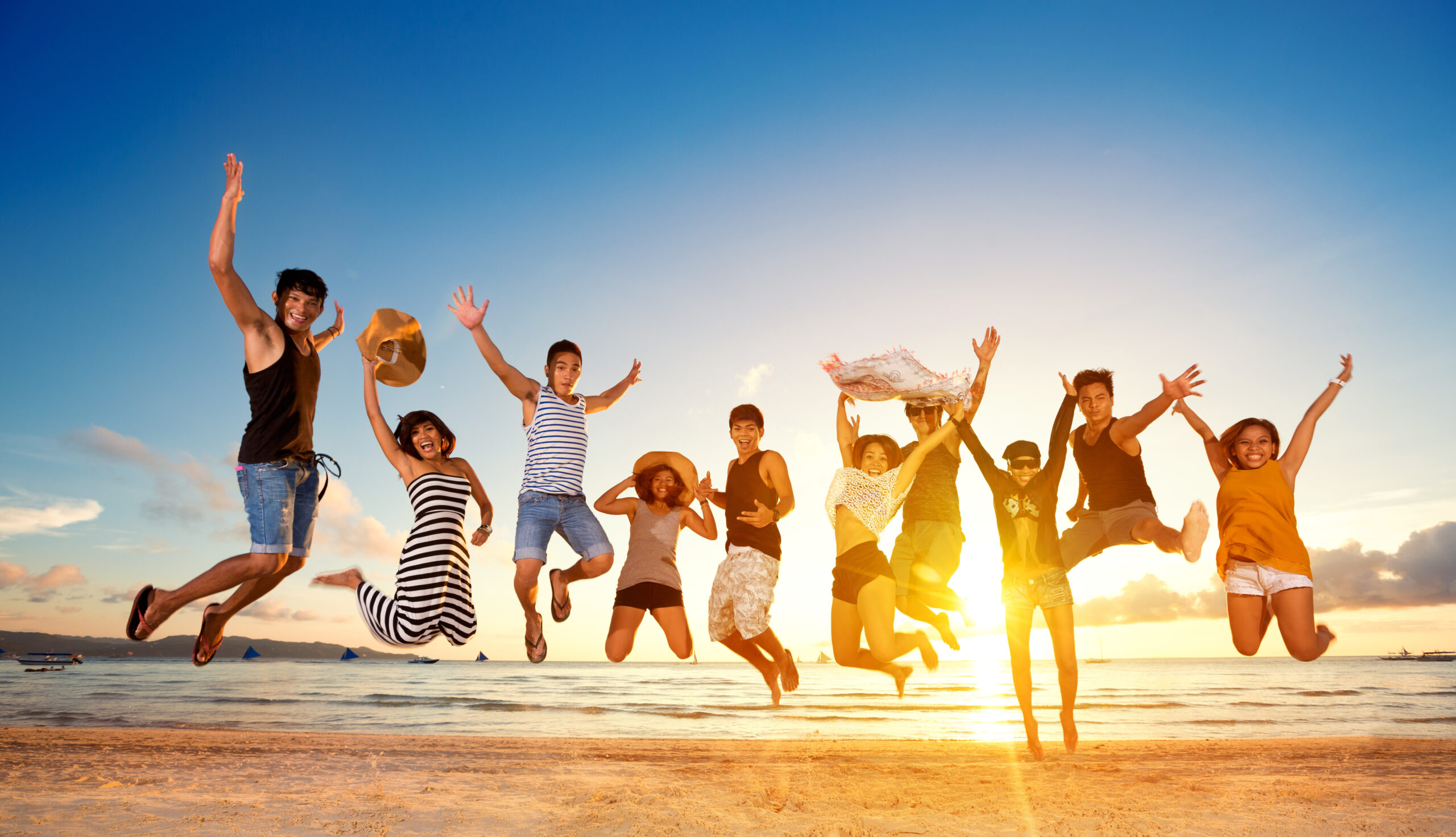 group of friends jumping on beach