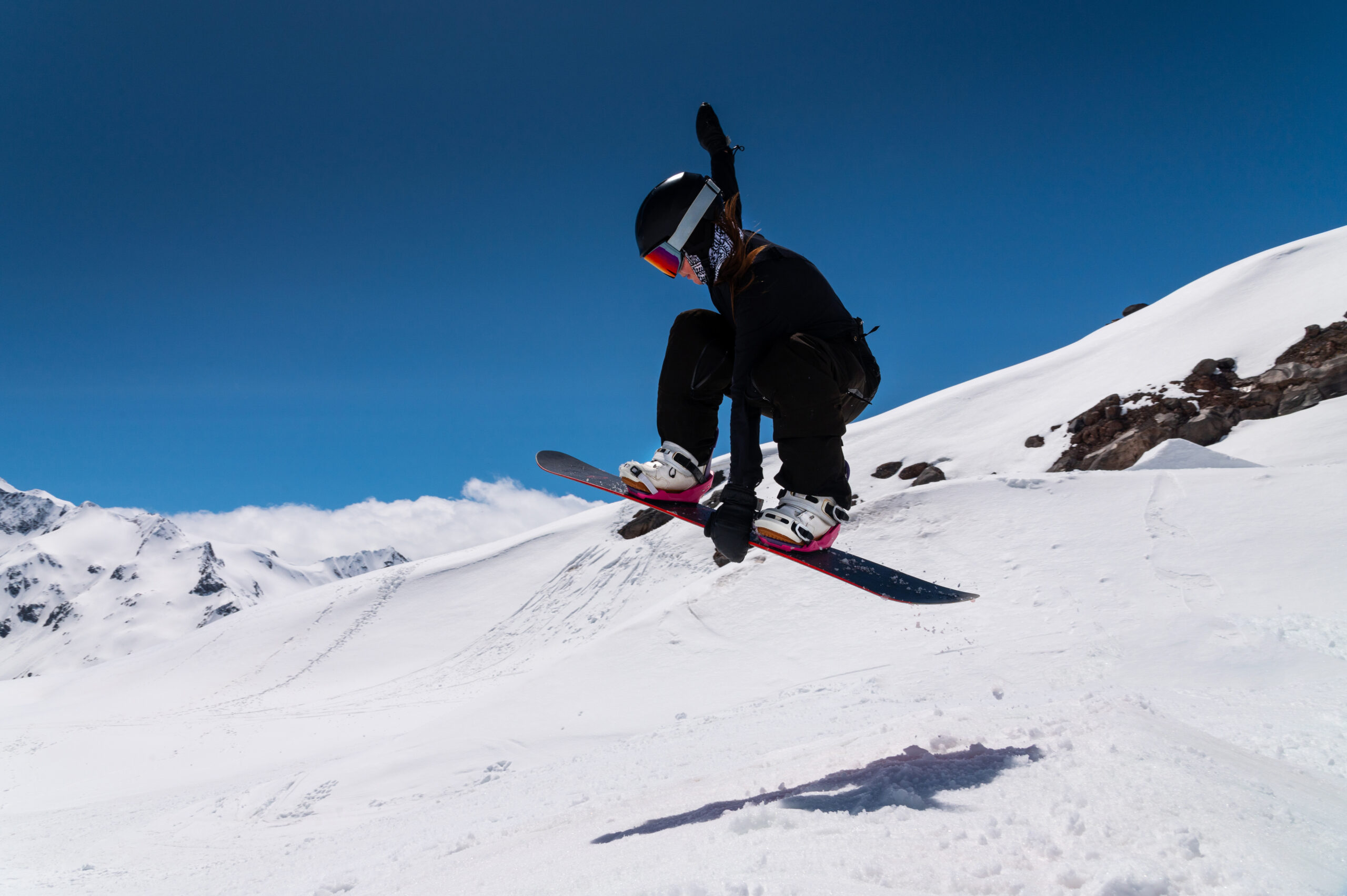 femme faisant snowboard en dans les montagnes enneigées
