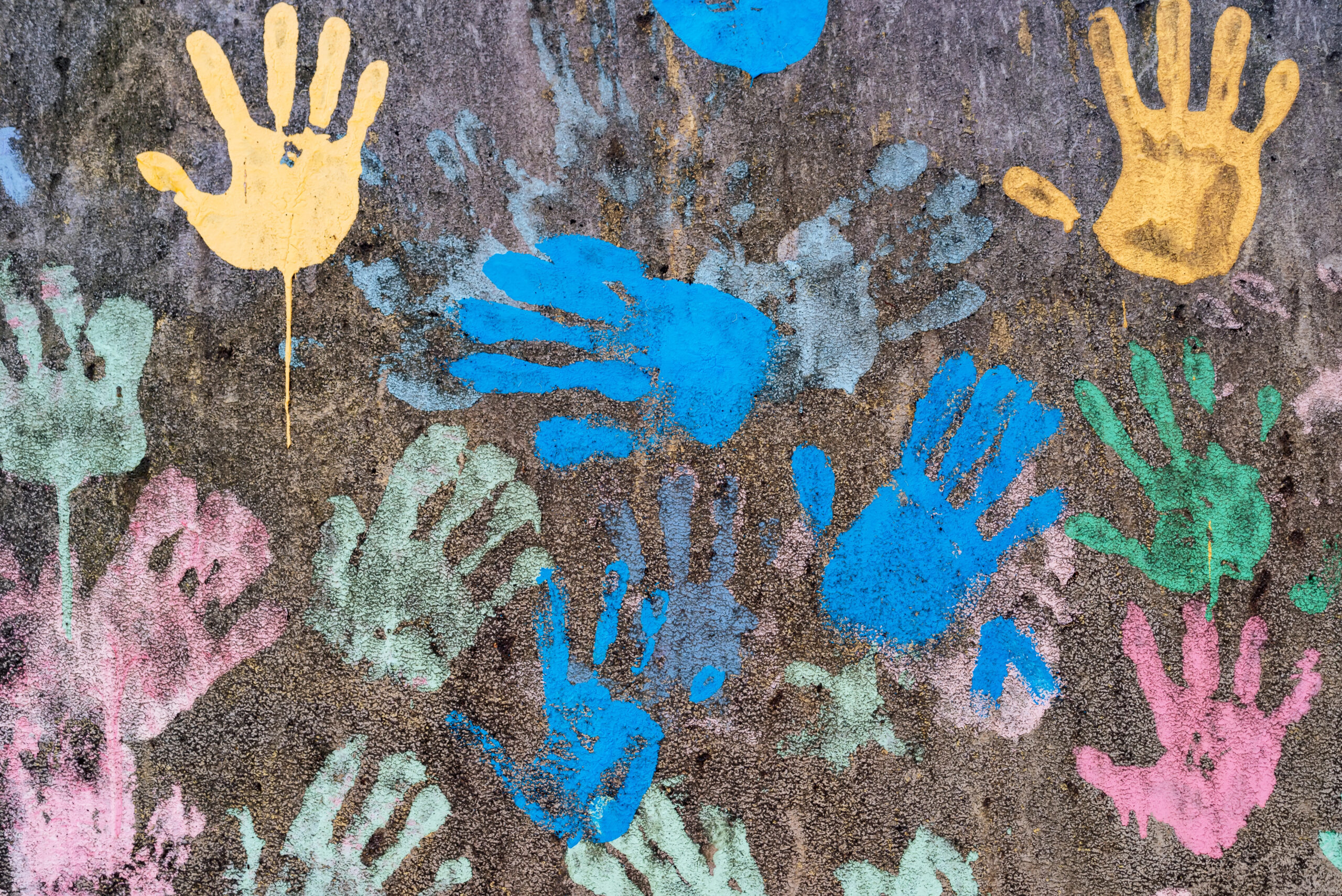 dark background with colorful handprints symbolising interracial friendship